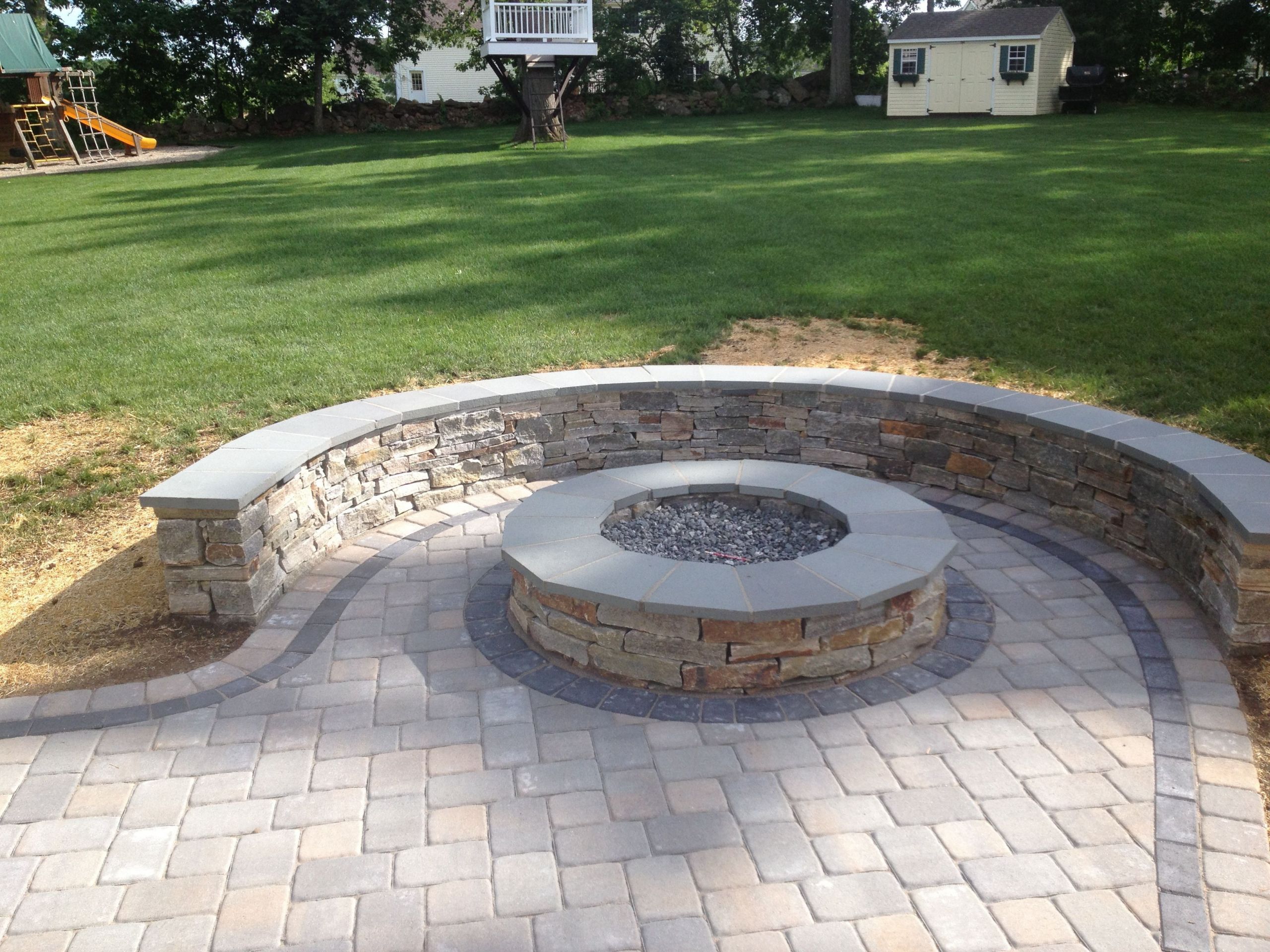 Paving Stones Fire Pit
 Natural Stone sitting wall with bluestone cap surrounds a