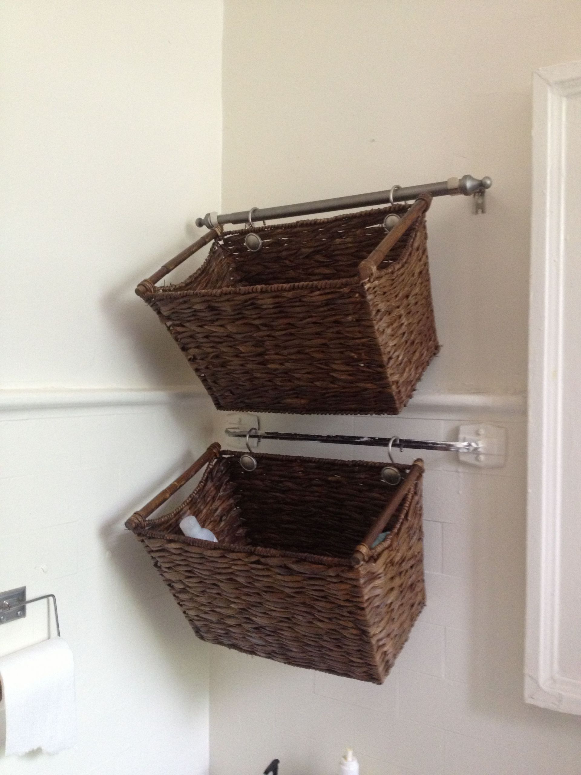 Bathroom Wall Baskets
 Cut down a curtain rod and hang wicker baskets for cute