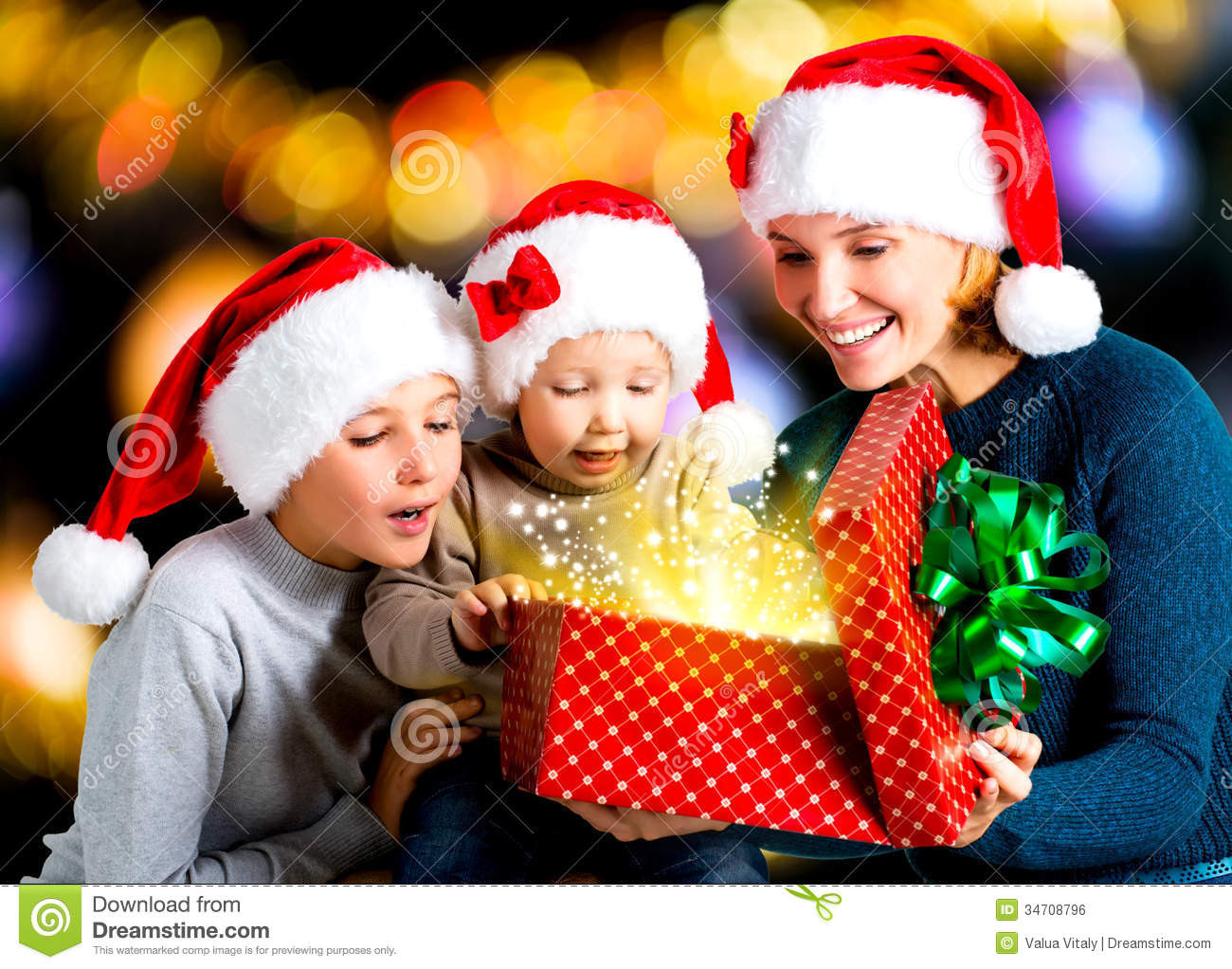 Free Christmas Gifts For Children
 Mother With Children Opens The Box With Gifts The